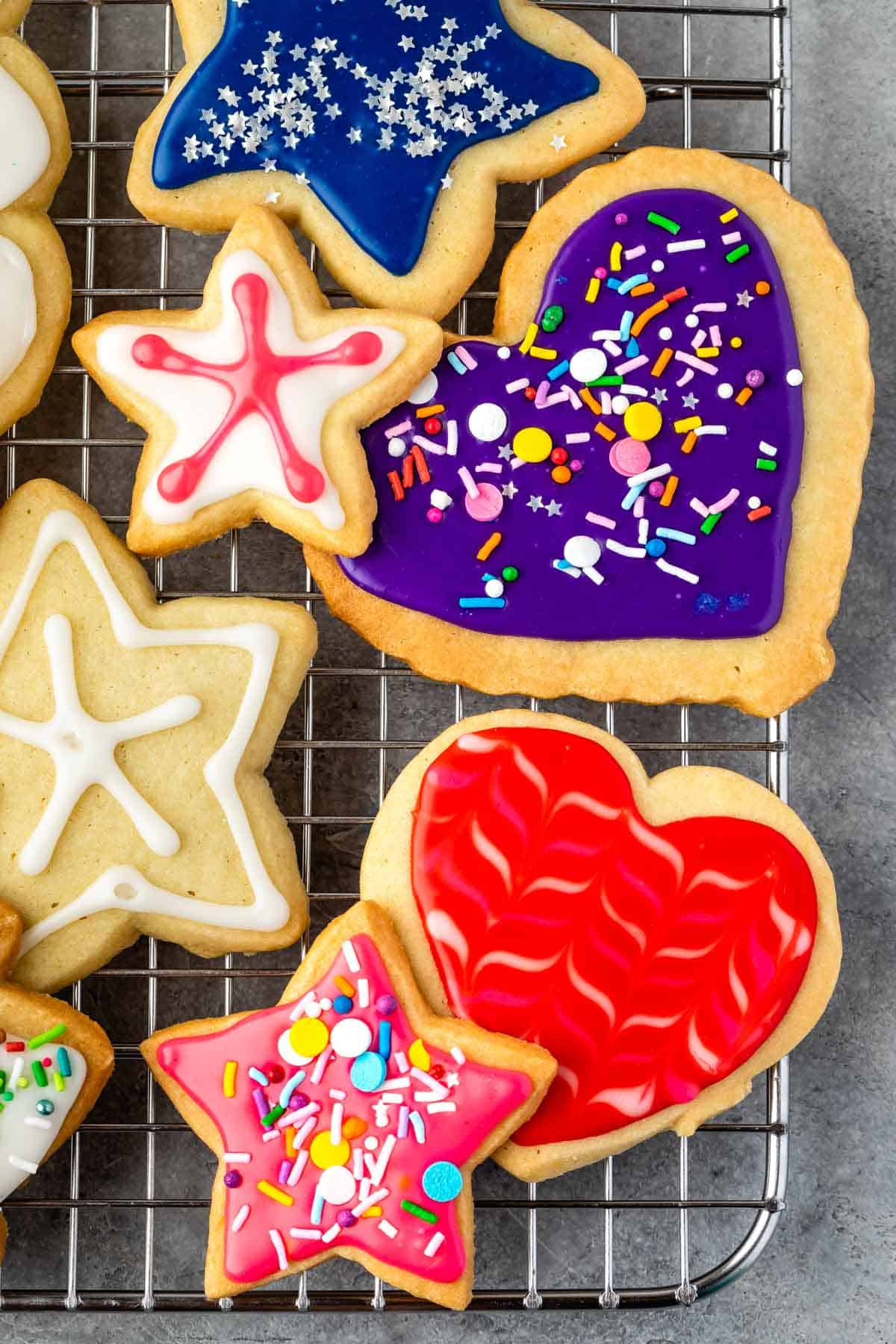 sugar cookies with various colored icing and sprinkles on top