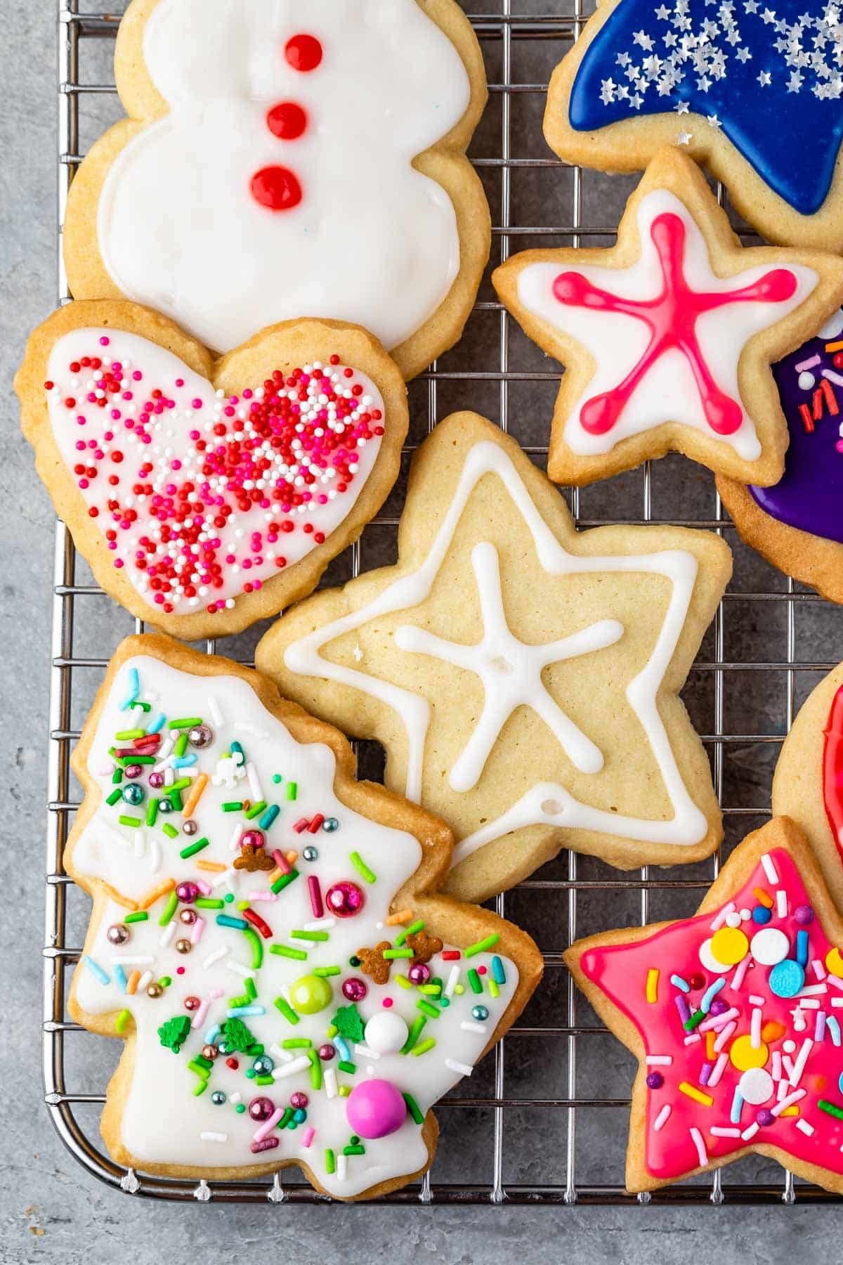 sugar cookies with various colored icing and sprinkles on top