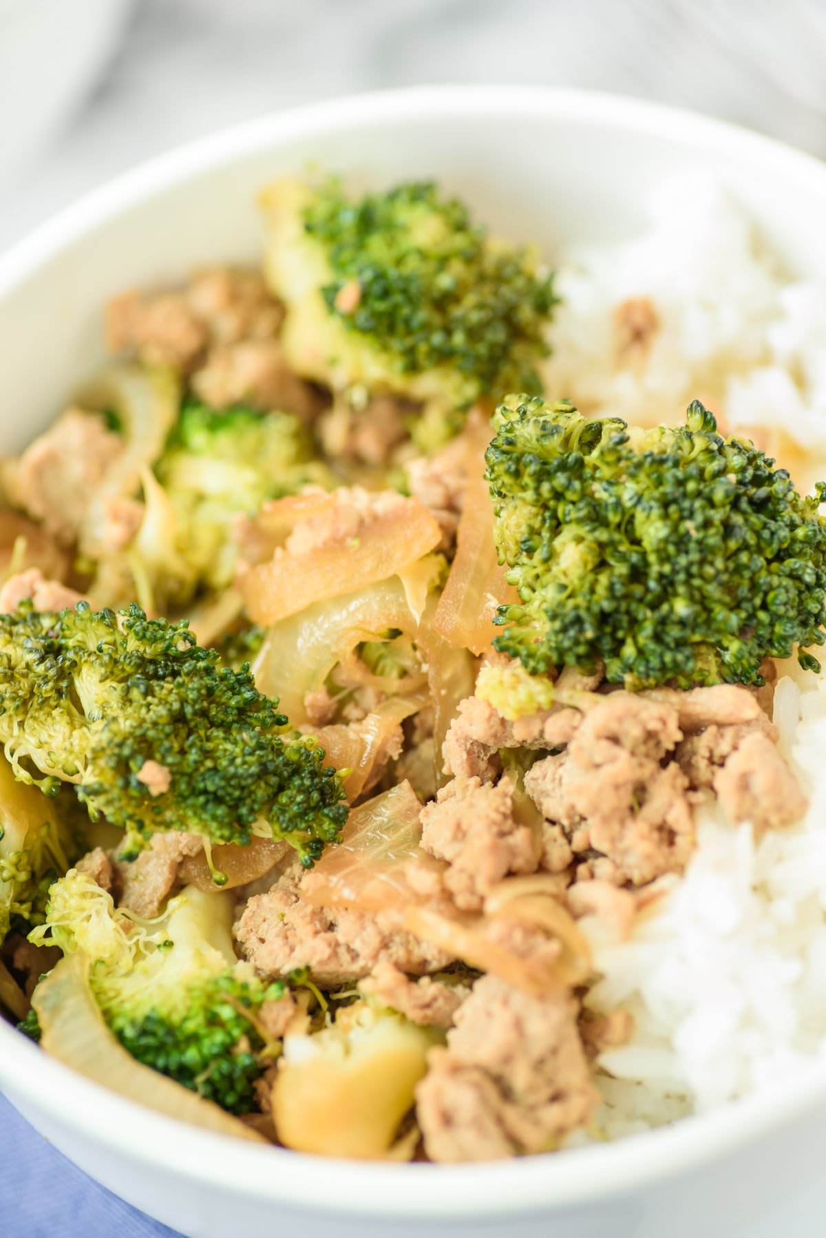 broccoli and meat mixed together in a white bowl