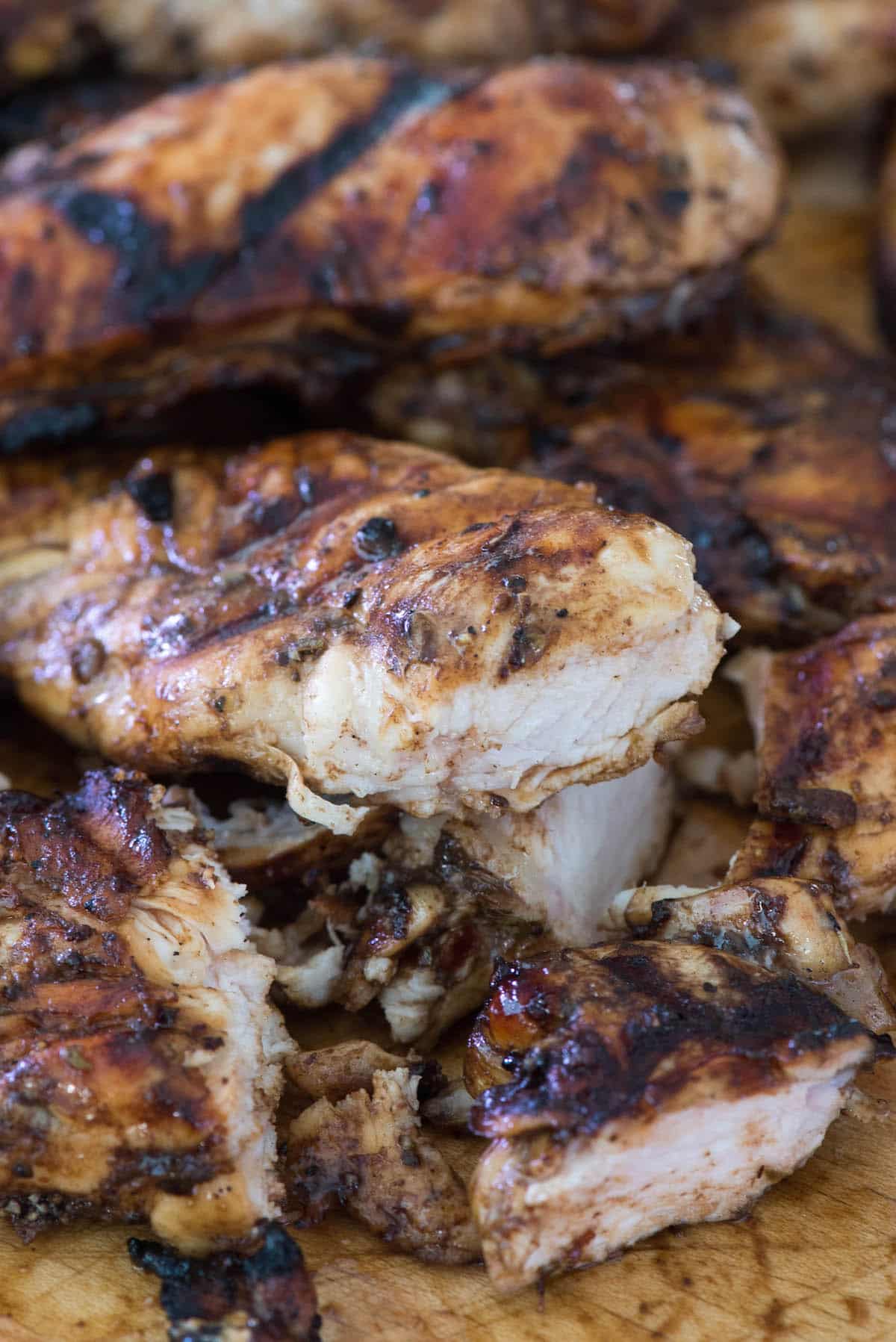 chicken pulled on a wooden cutting board.