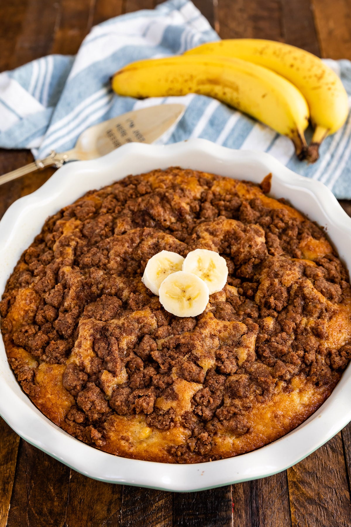 coffee cake on a white plate next to some banana slices.