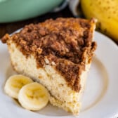 coffee cake on a white plate next to some banana slices.