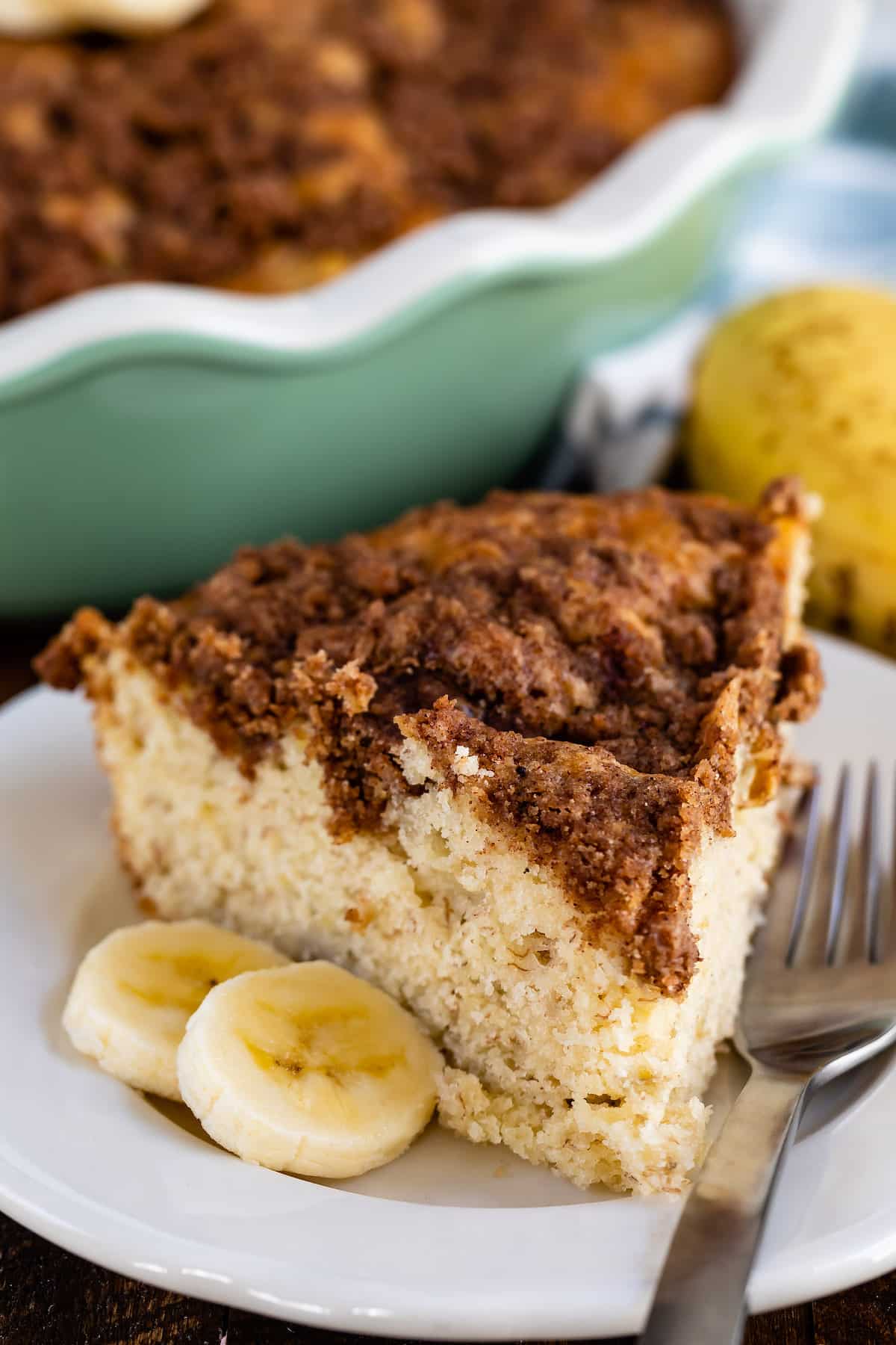 coffee cake on a white plate next to some banana slices.