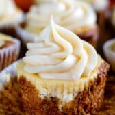 cupcakes with tan frosting on a cutting board.