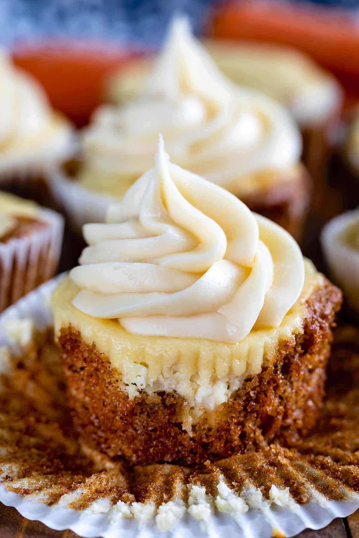 cupcakes with tan frosting on a cutting board.