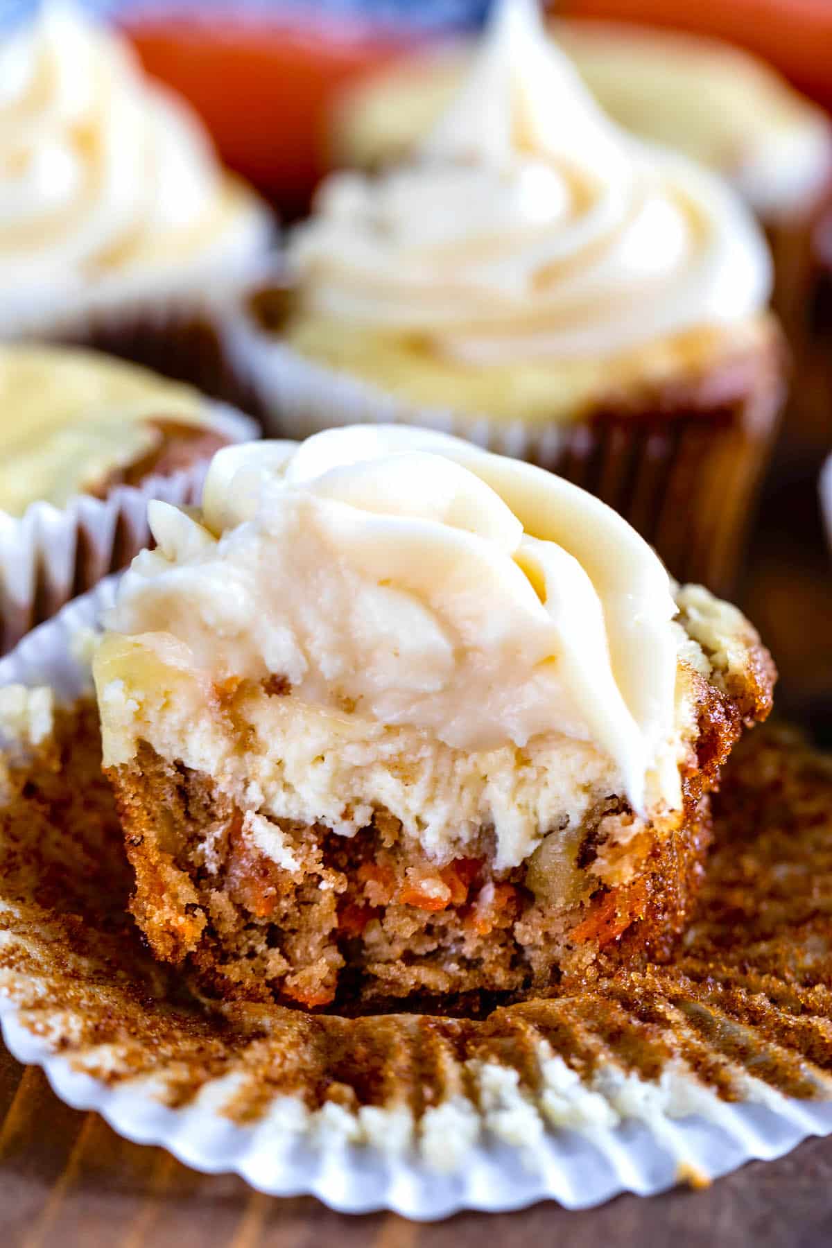 cupcakes with tan frosting on a cutting board.