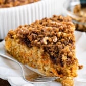 one slice of coffee cake with carrots baked in on a white plate.