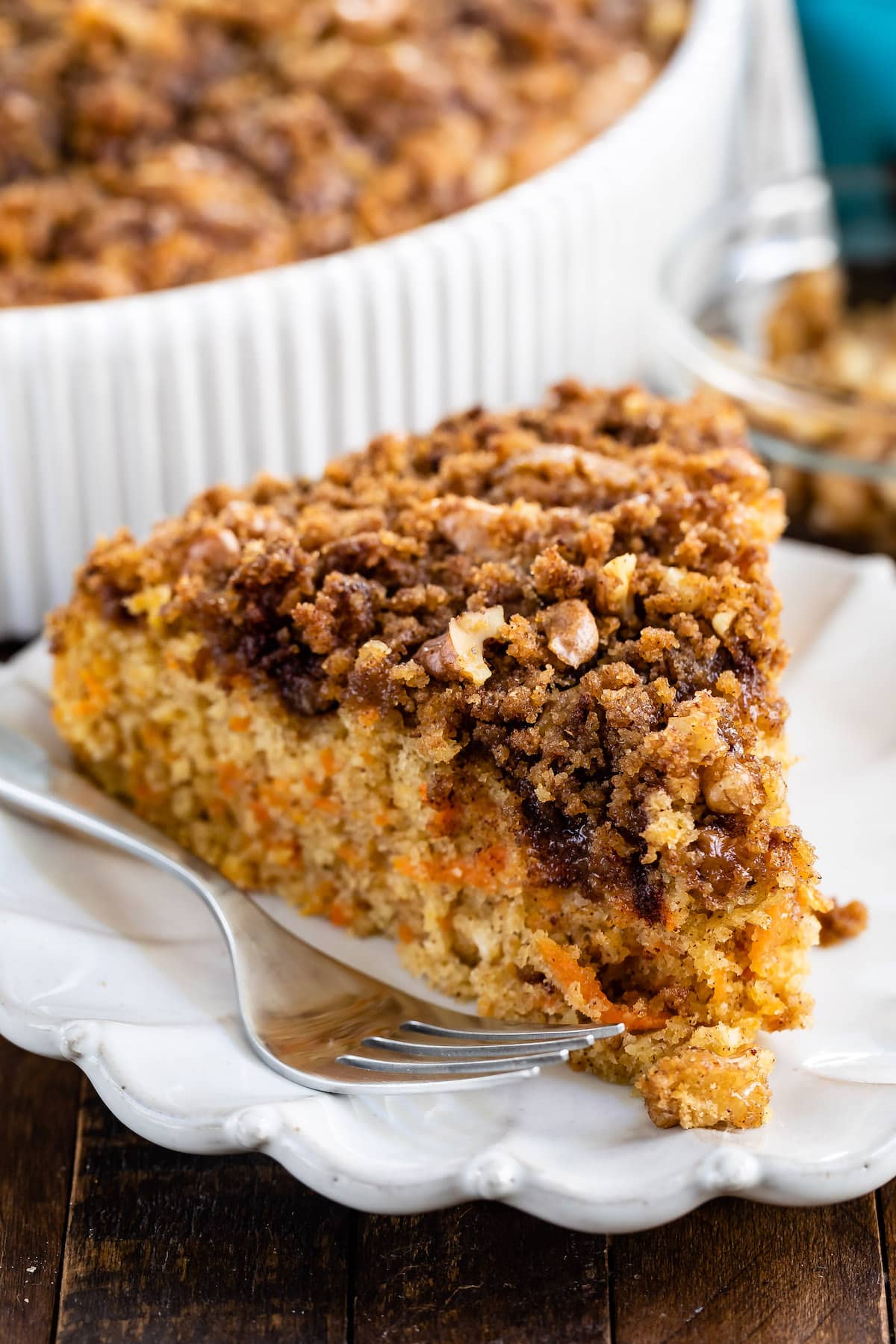 one slice of coffee cake with carrots baked in on a white plate.