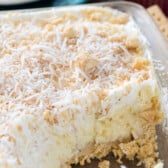 no bake dessert with coconut on top in a clear pan.