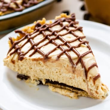 pie on a white plate covered in chocolate frosting.