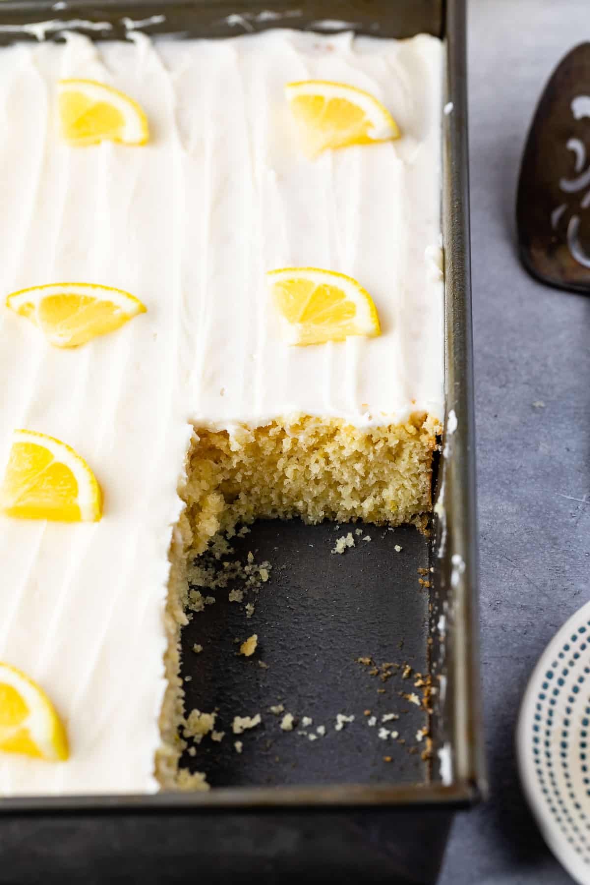 lemon cake with white frosting and a lemon slice on top.