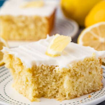 lemon cake with white frosting and a lemon slice on top.