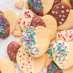 heart shaped cookies half covered in chocolate and sprinkles.