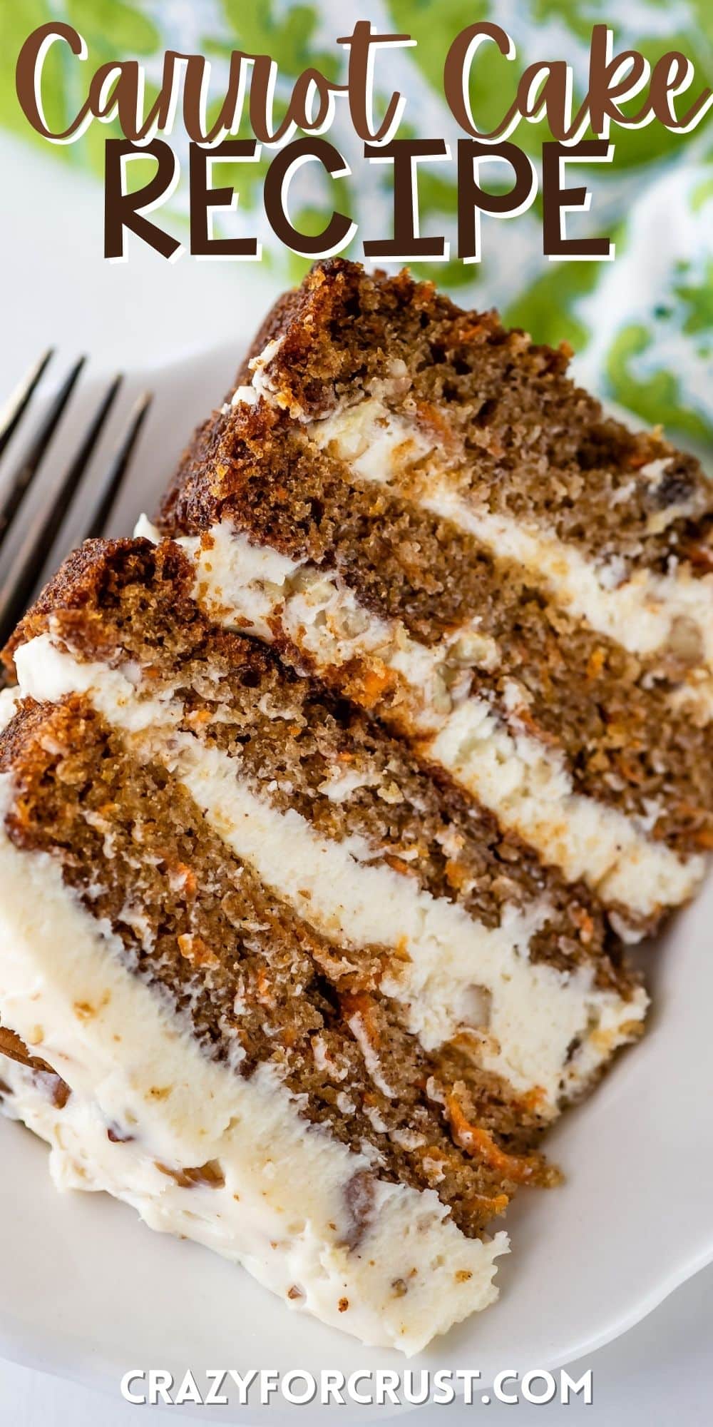 carrot cake layered with white frosting and decorated with pecans on a white plate with words on the image.