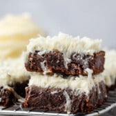 stacked brownies with white frosting mixed with coconuts.