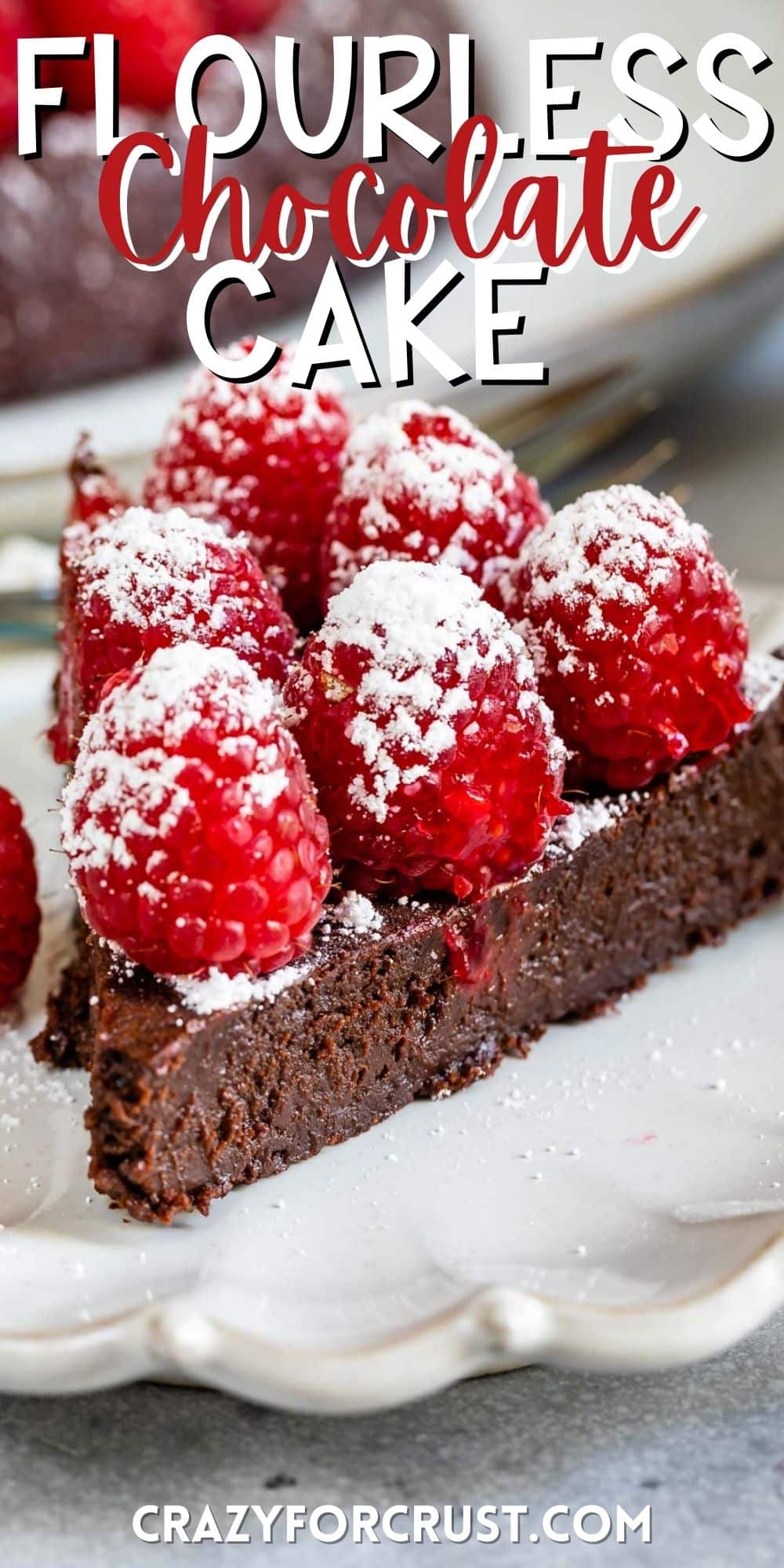 triangle shaped chocolate cake sitting on a grey plate topped with raspberries with words on the image.
