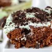 chocolate cake with mint frosting and oreo pieces on top.