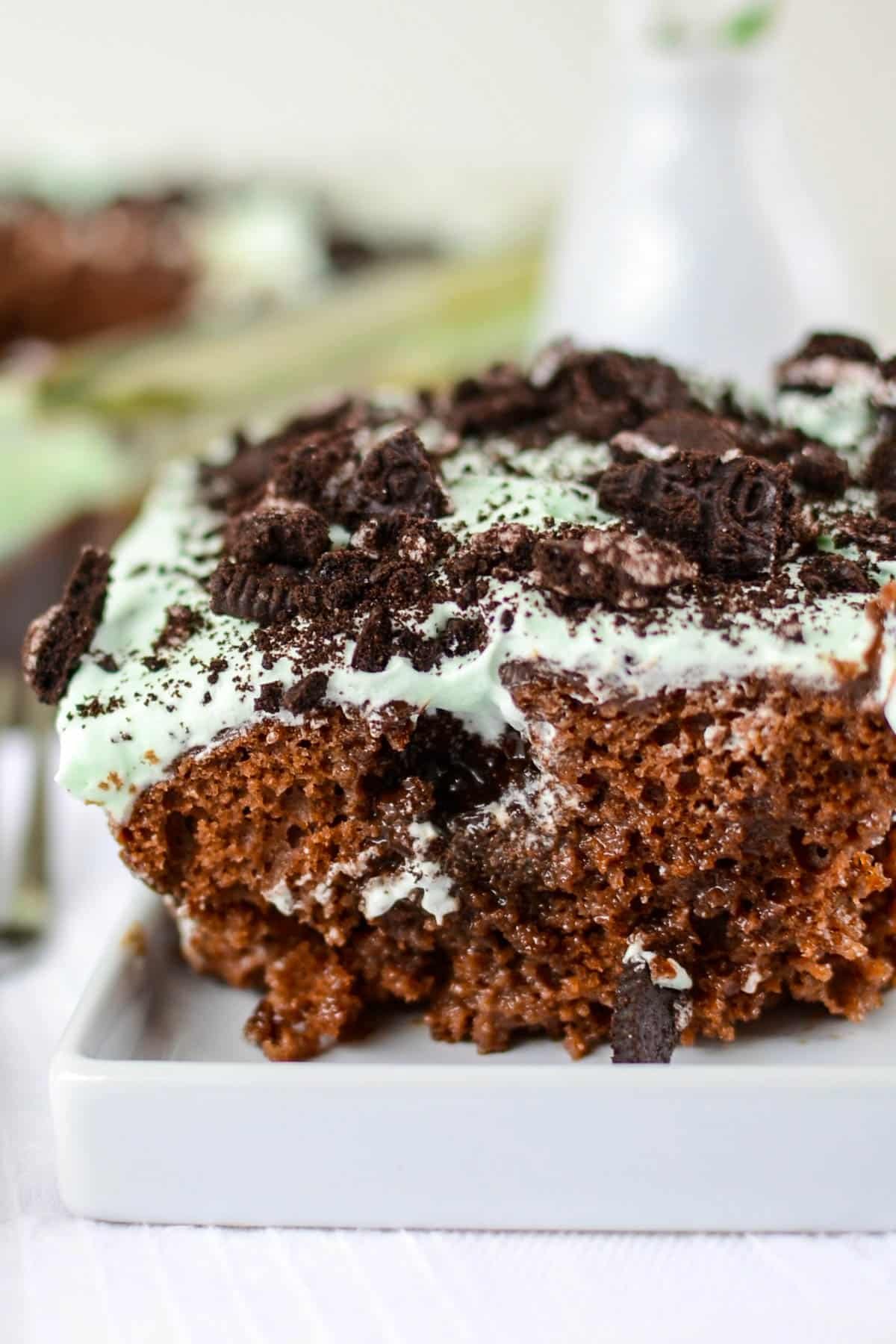 chocolate cake with mint frosting and oreo pieces on top.