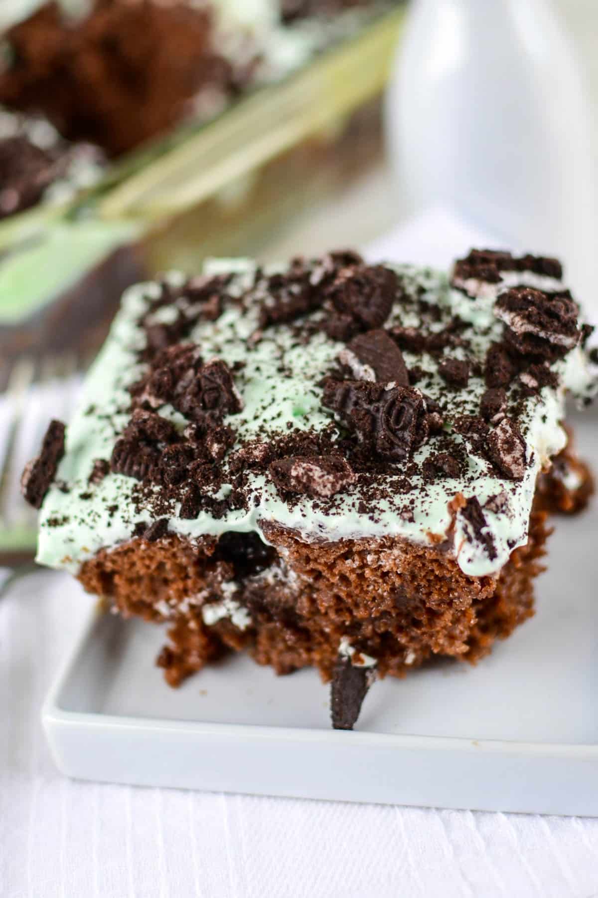 chocolate cake with mint frosting and oreo pieces on top.