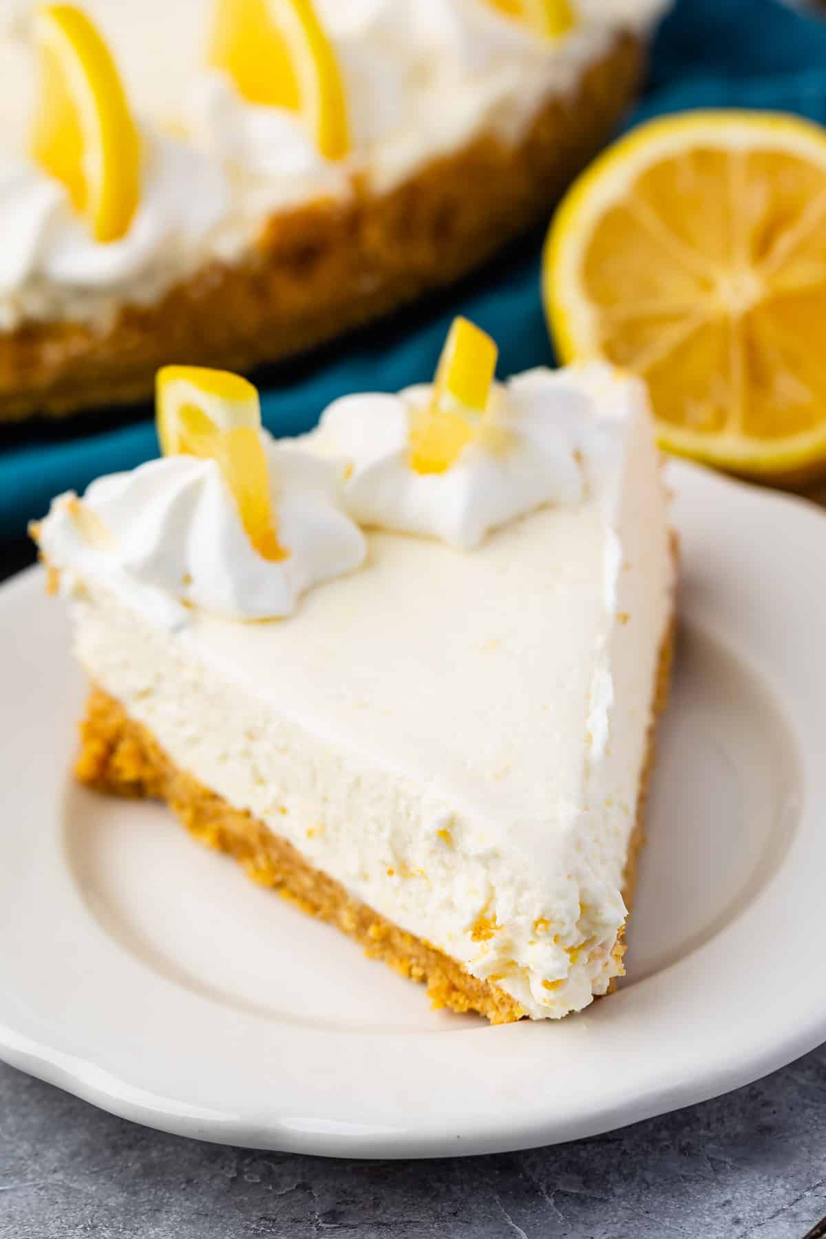 triangle slice of cheesecake with lemon slices on top.