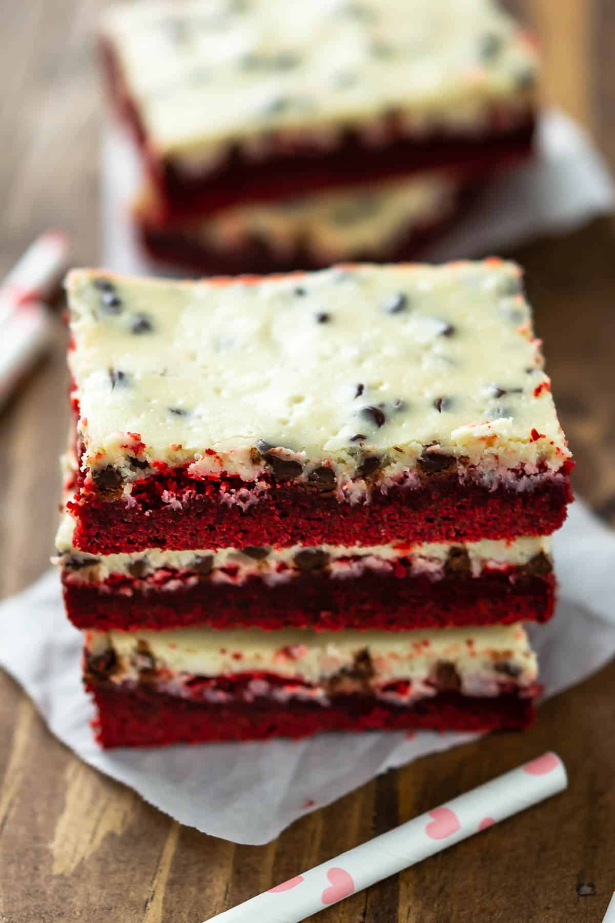 stacked red velvet bars with a yellow top of frosting.