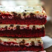 stacked red velvet bars with a yellow top of frosting.