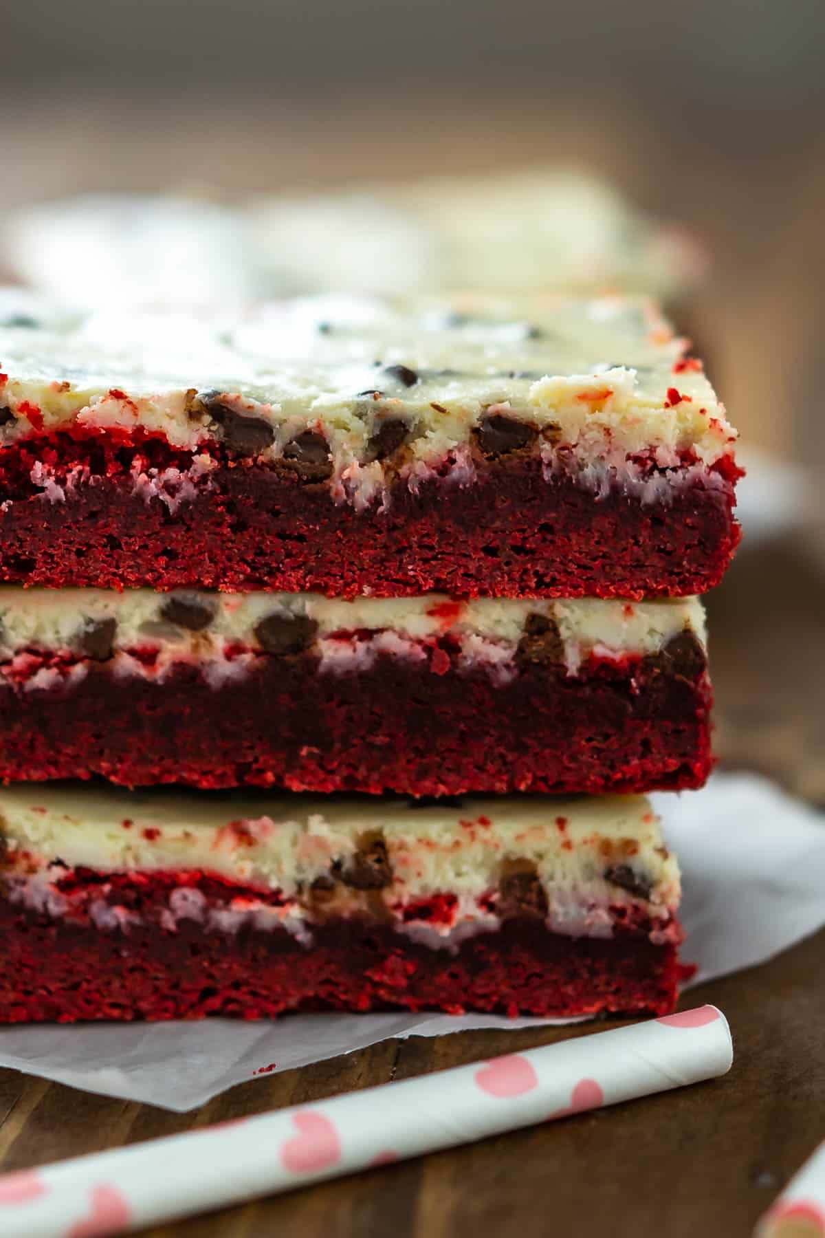 stacked red velvet bars with a yellow top of frosting.