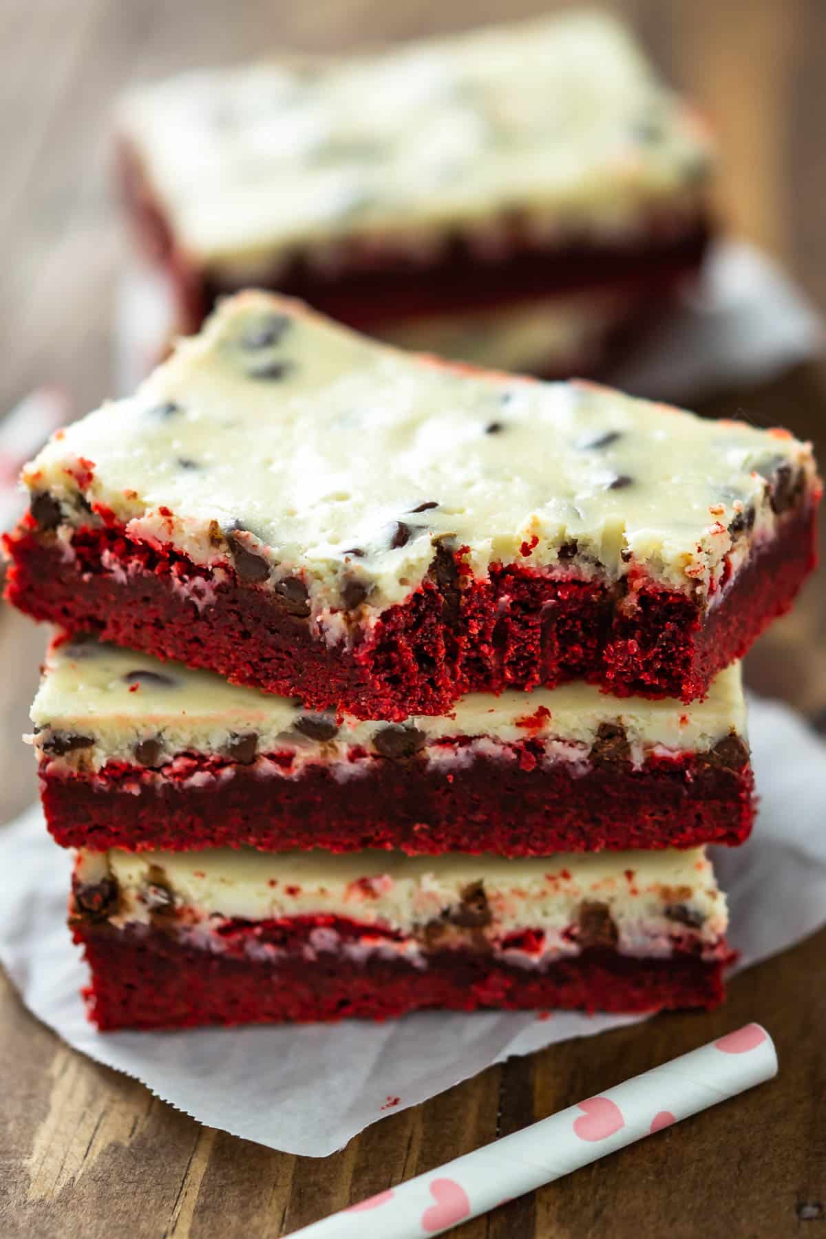 stacked red velvet bars with a yellow top of frosting.