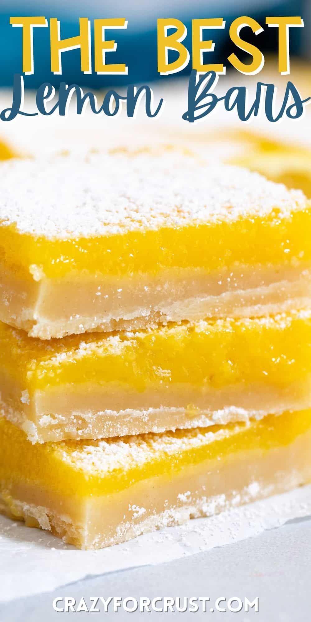 stacked lemon bars with powdered sugar on top around cut lemons with words on the image.