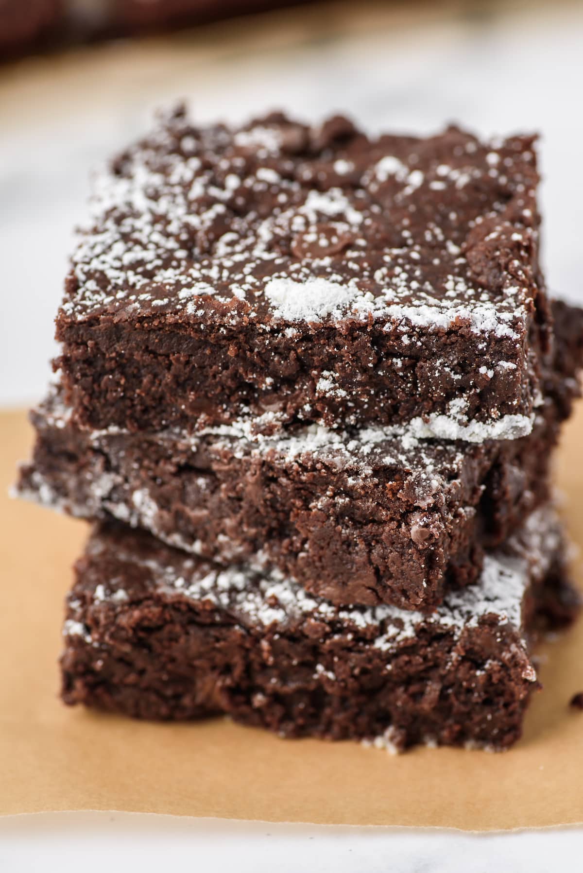 stacked brownies with powdered sugar sprinkled on top.