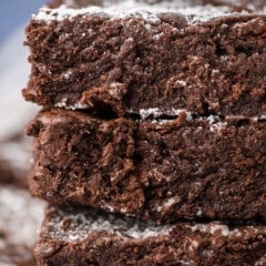 stacked brownies with powdered sugar sprinkled on top.