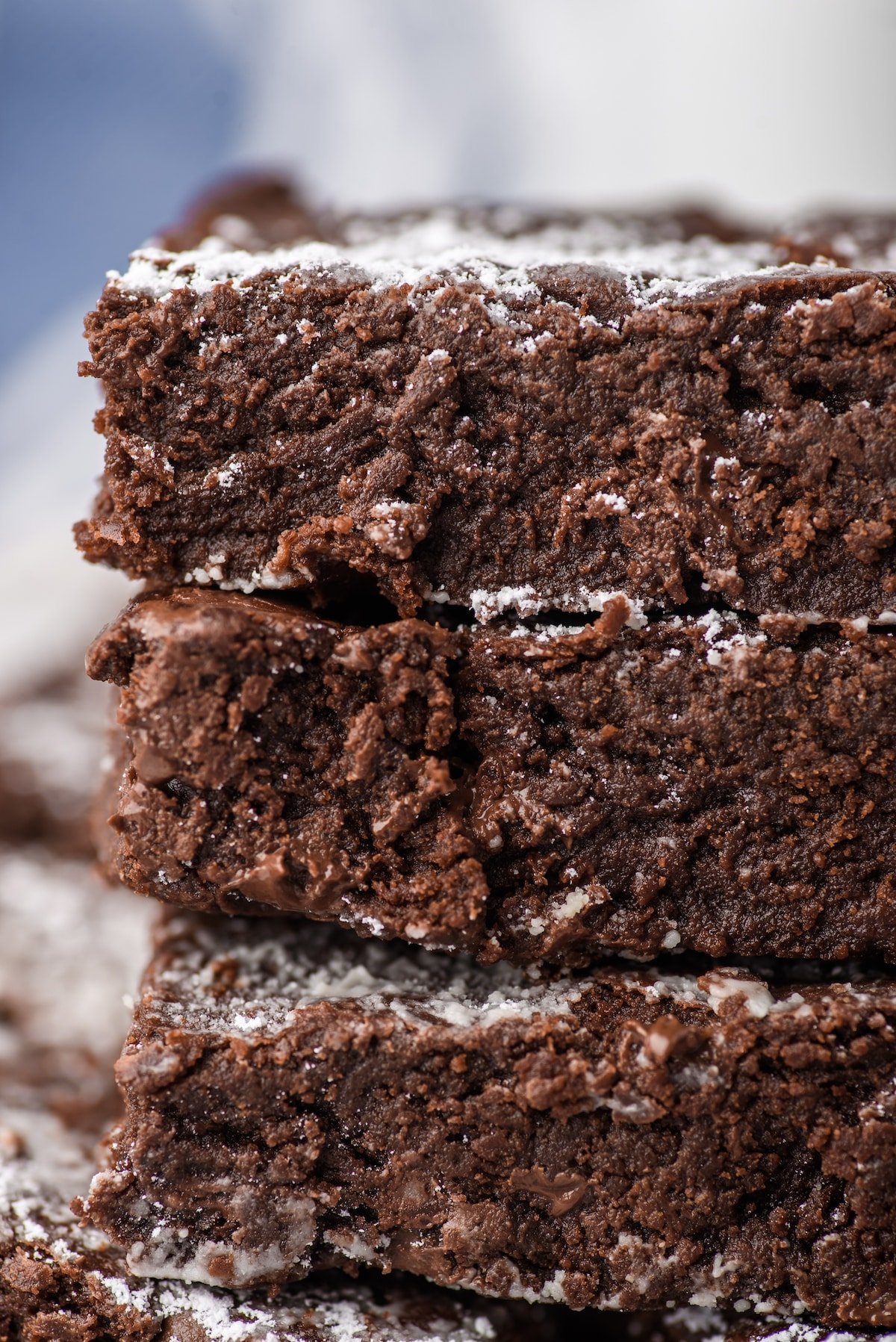 stacked brownies with powdered sugar sprinkled on top.