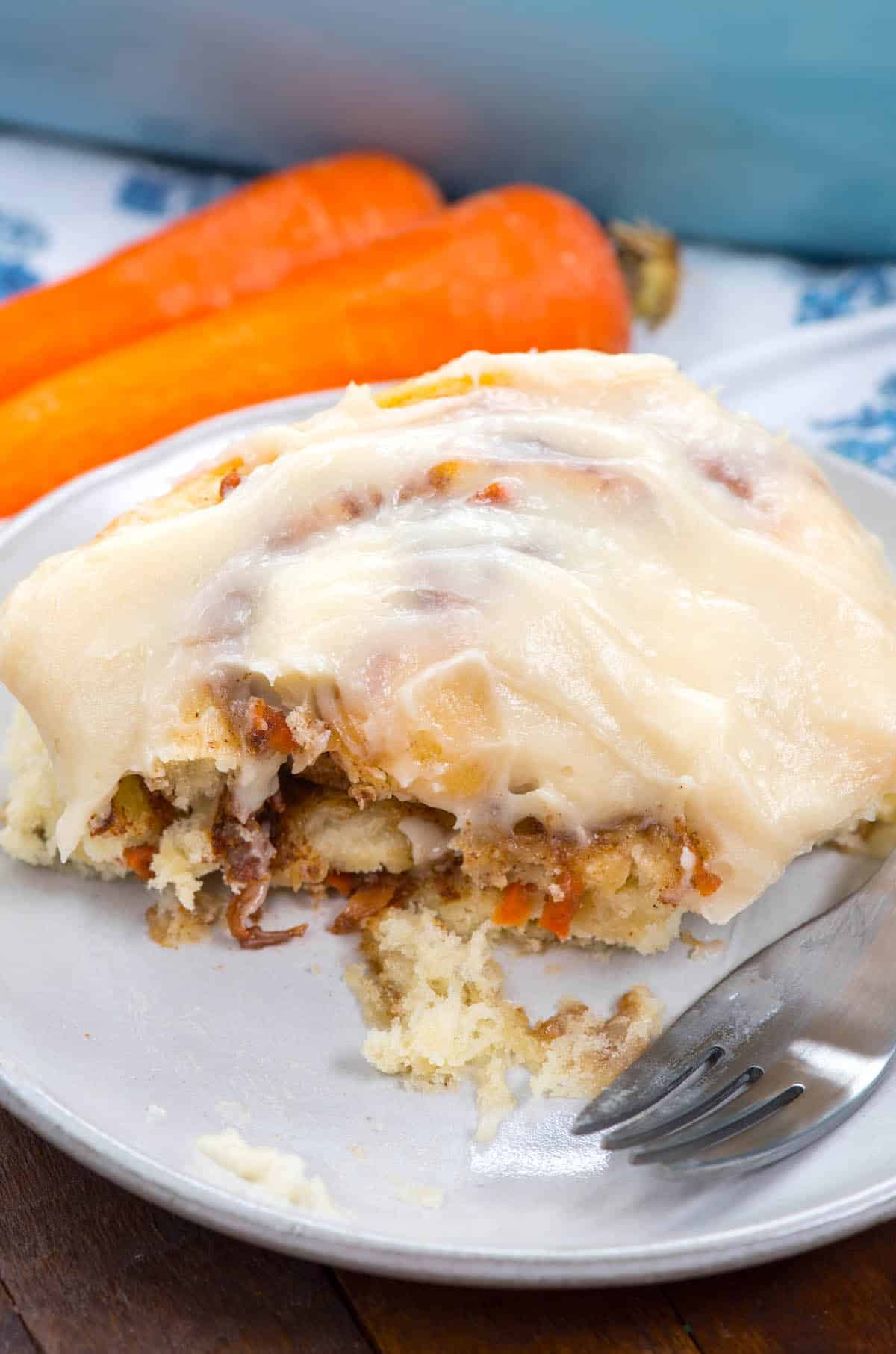 cinnamon rolls with carrots baked in on a white plate.