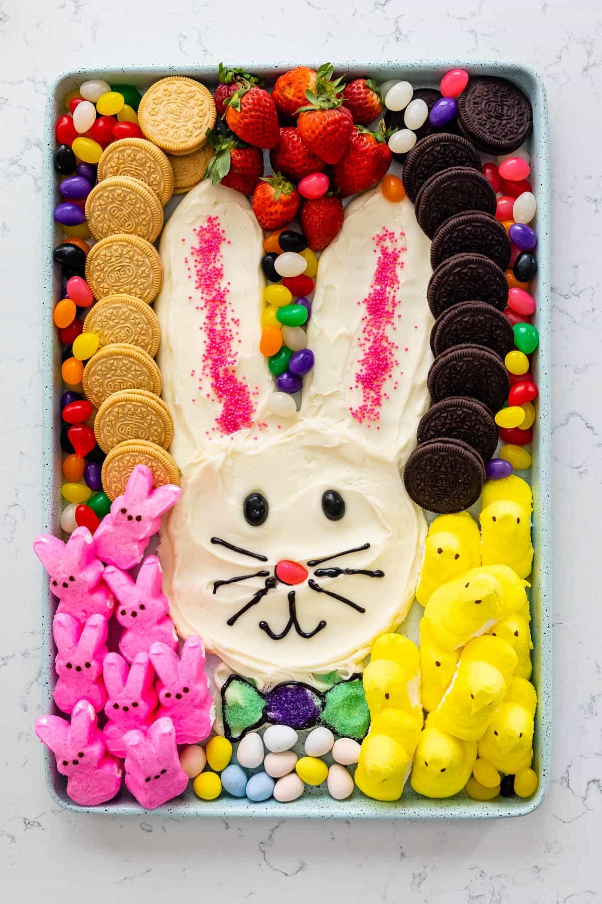 bunny shaped out of frosting and surrounded by jelly beans, marshmallows and oreos.