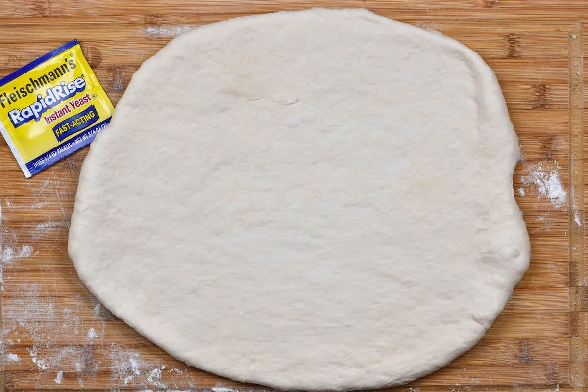 bread dough rolled out on cutting board