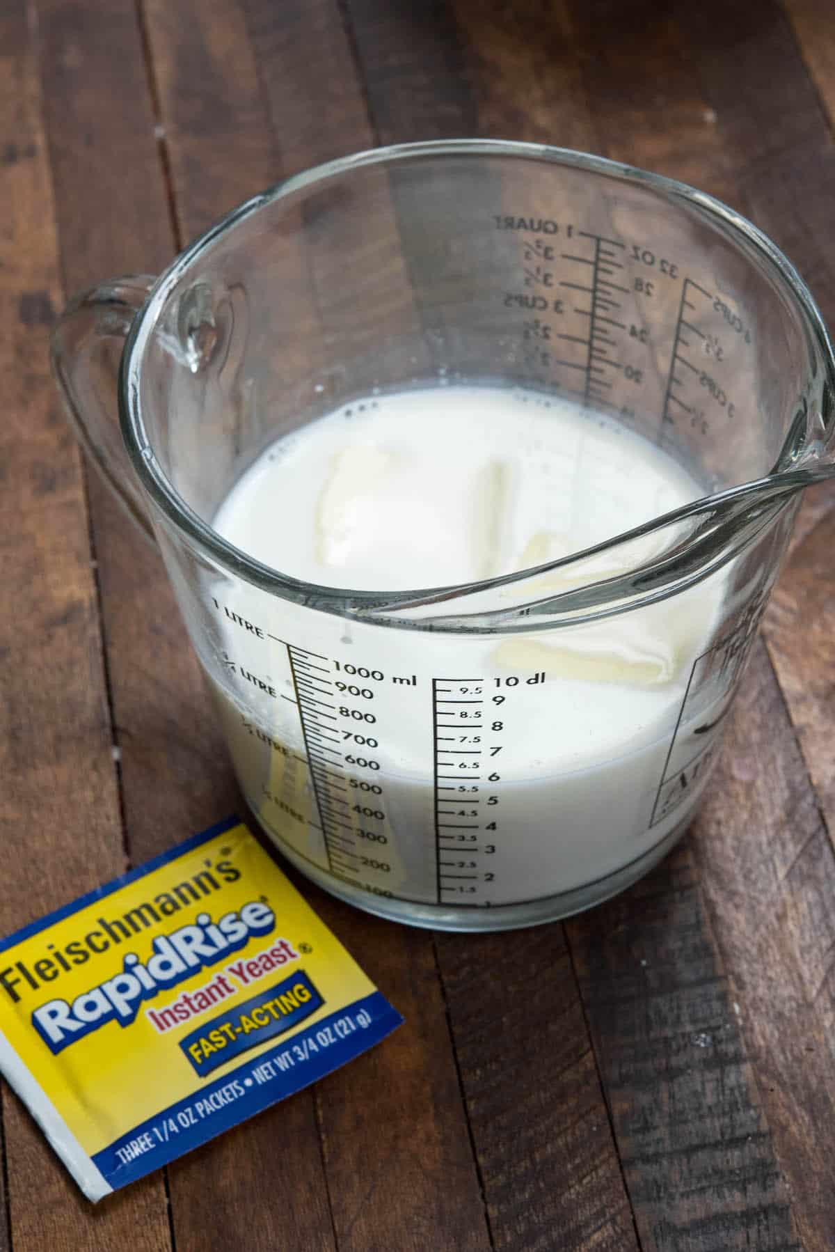 milk and butter in measuring cup on wood surface.