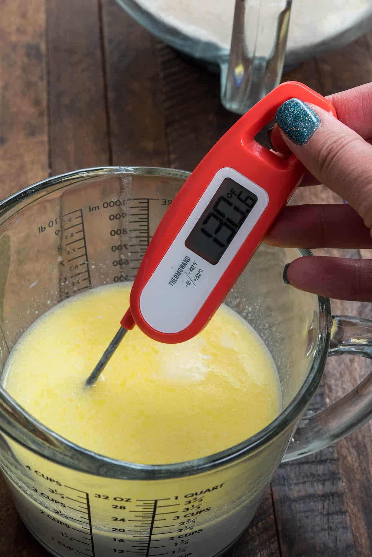 thermometer in butter milk mixture in measuring cup.