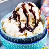 ice cream in blue bowls with chocolate sauce drizzled over the ice cream.