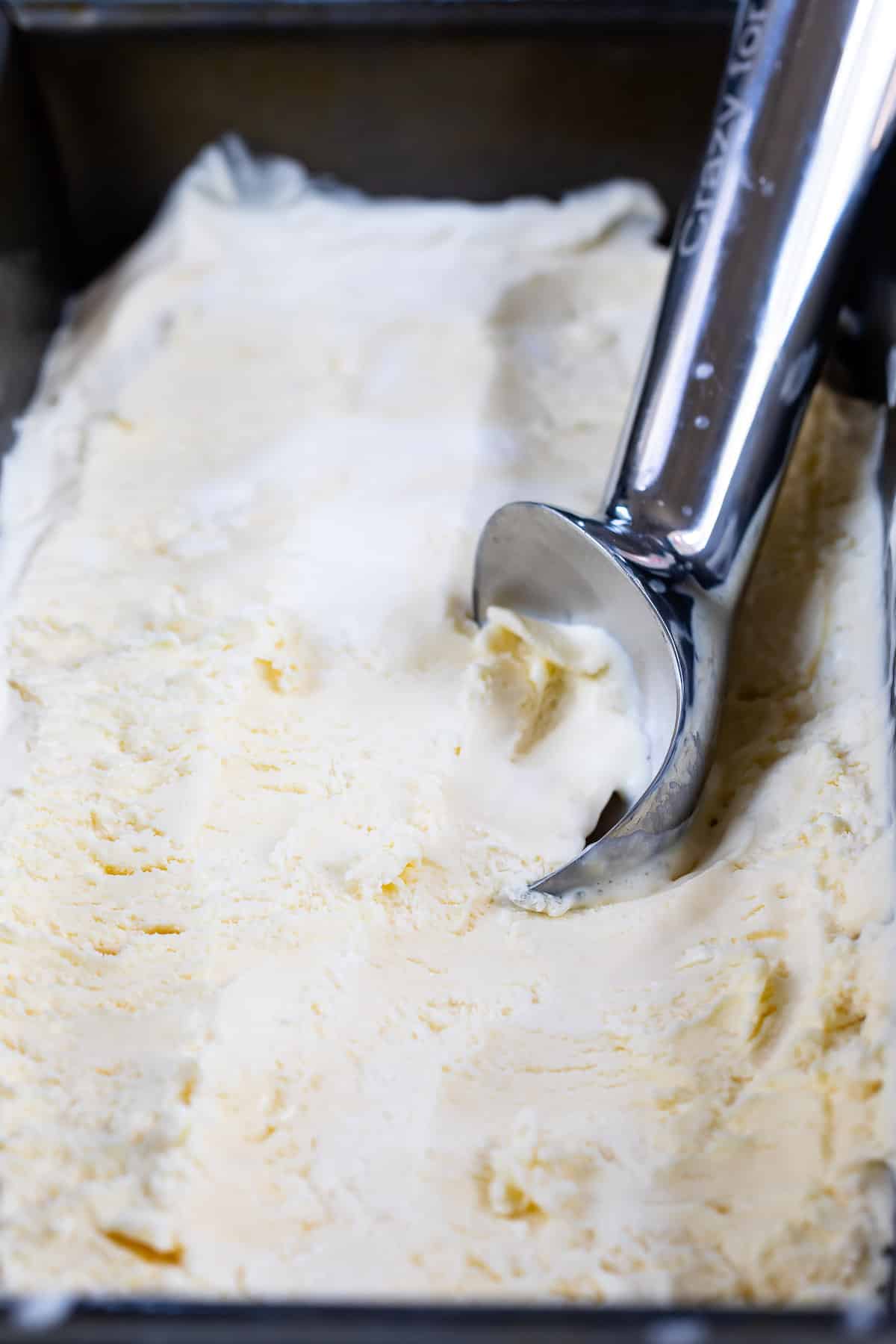 ice cream being scooped out of the ice cream tin.