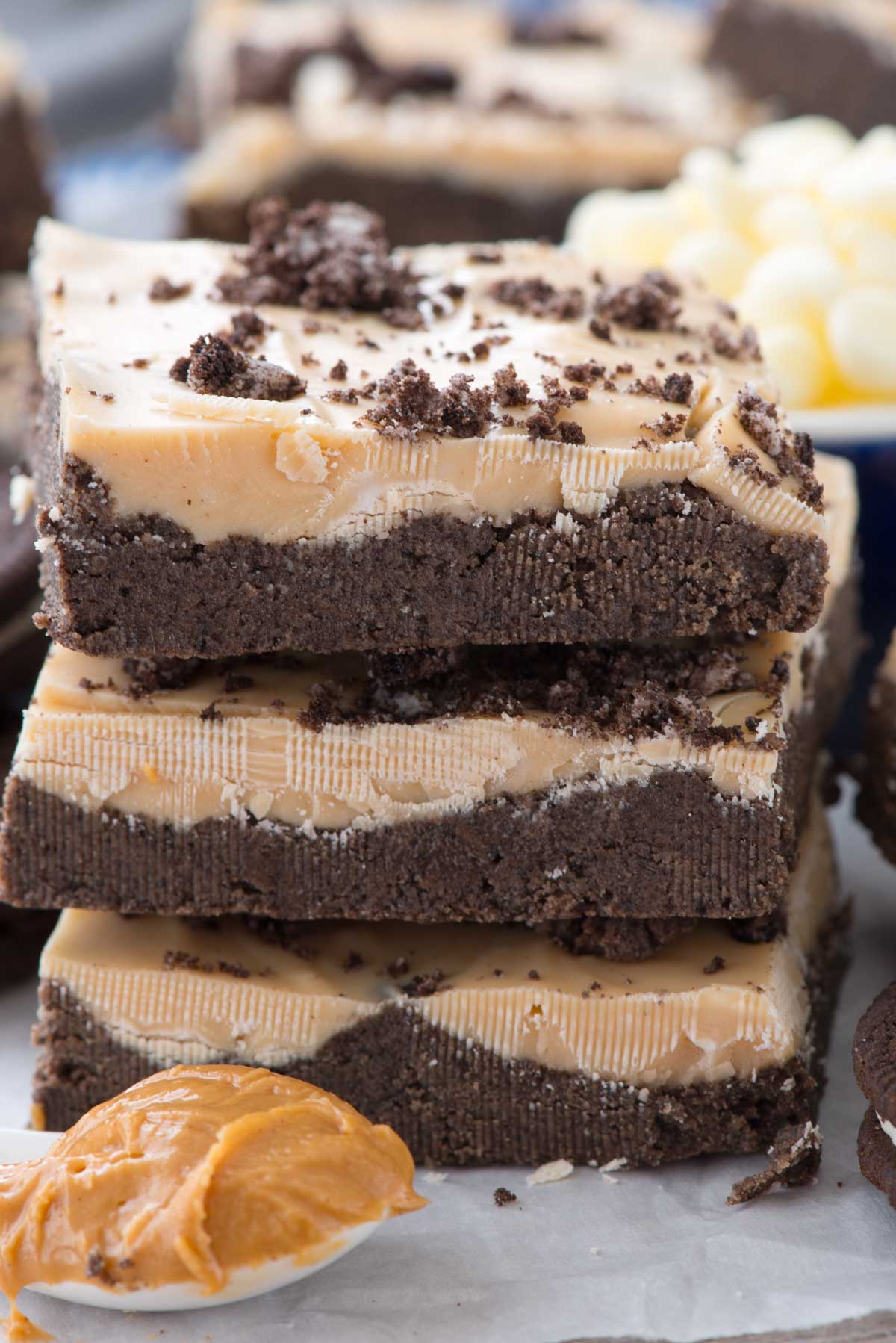 stacked chocolate and peanut butter layer bars with oreo crumble on top.