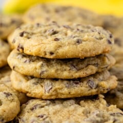 stacked cookies with chocolate chips baked in and bananas in the back.