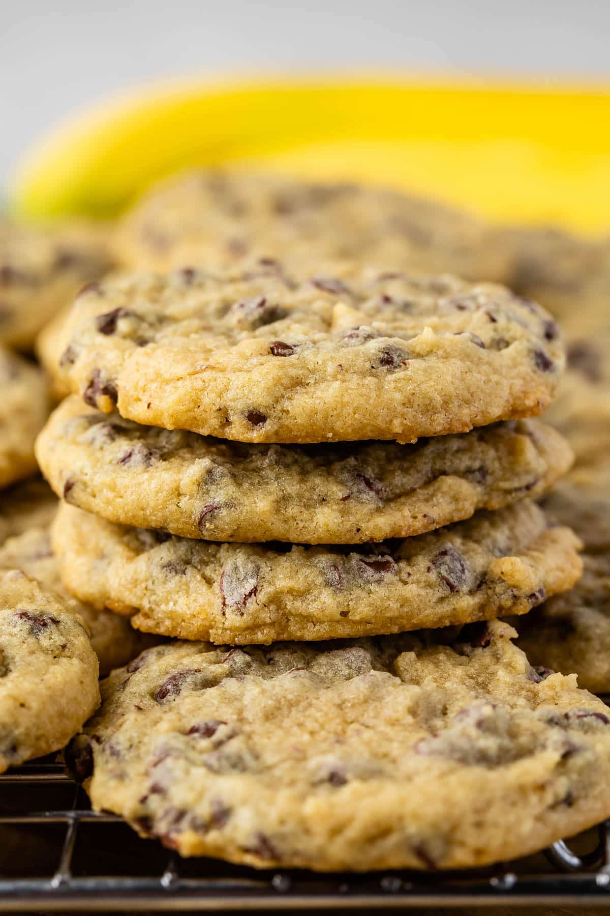 stacked cookies with chocolate chips baked in and bananas in the back.