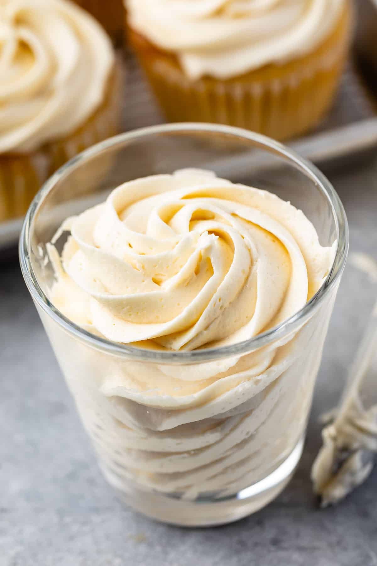 cream colored frosting swirled in a clear jar.