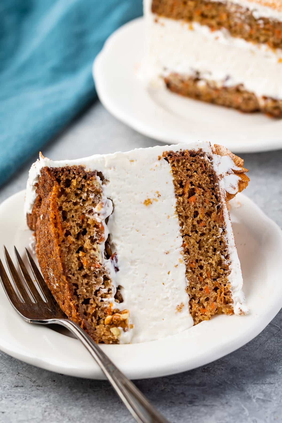 carrot cake covered in white frosting and cinnamon.