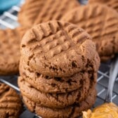 stacked chocolate cookie next to a spoonful of peanut butter.