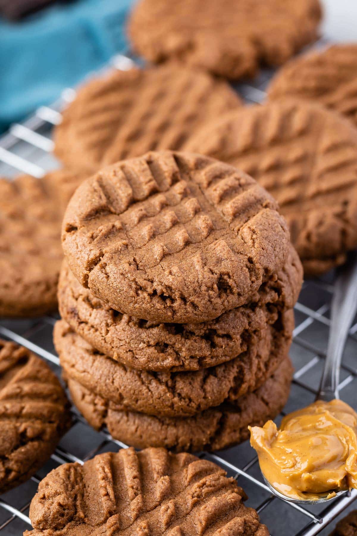 stacked chocolate cookie next to a spoonful of peanut butter.