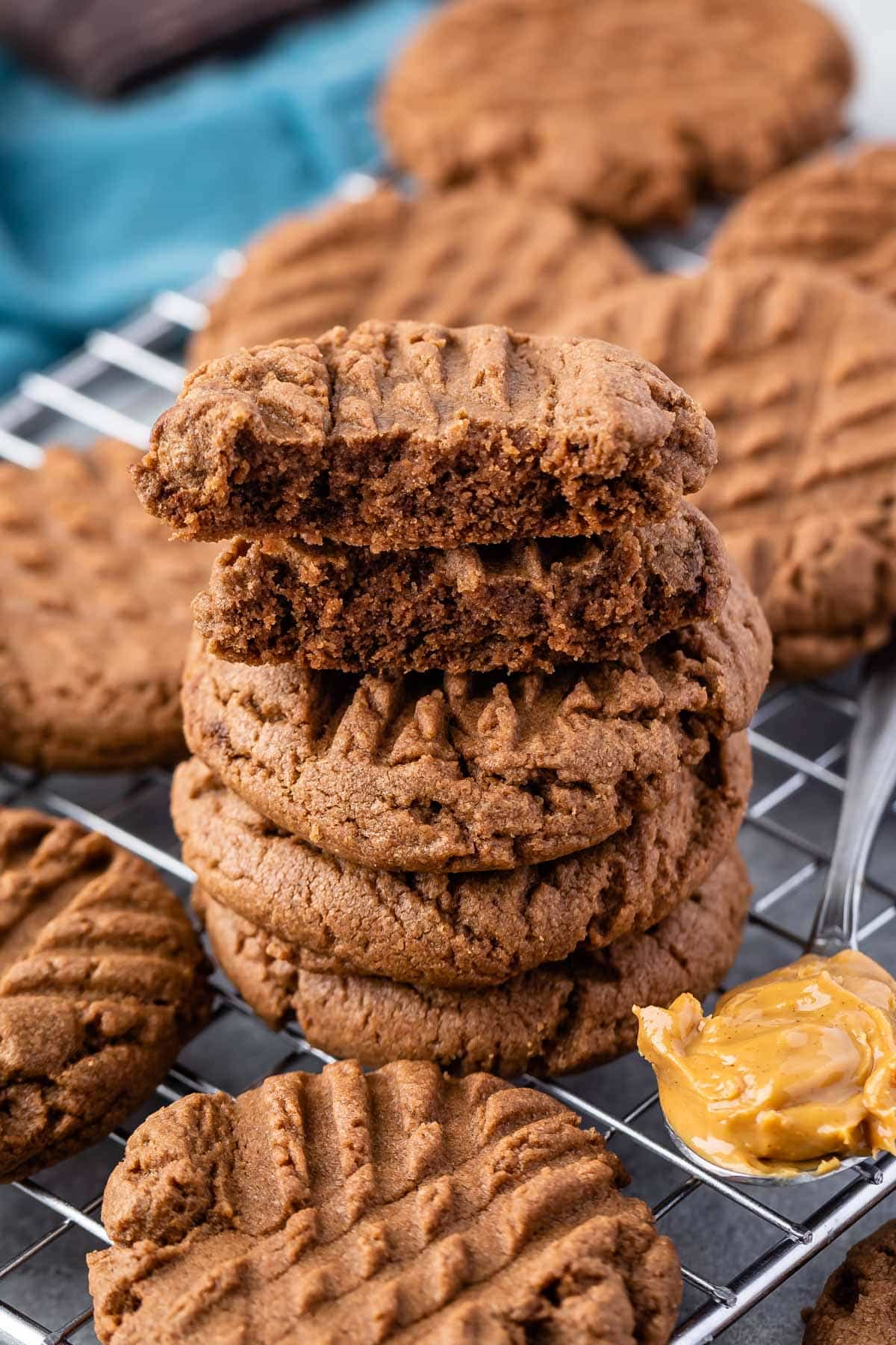 stacked chocolate cookie next to a spoonful of peanut butter.