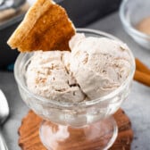 ice cream scooped into clear ice cream bowl and a churro piece mixed in.
