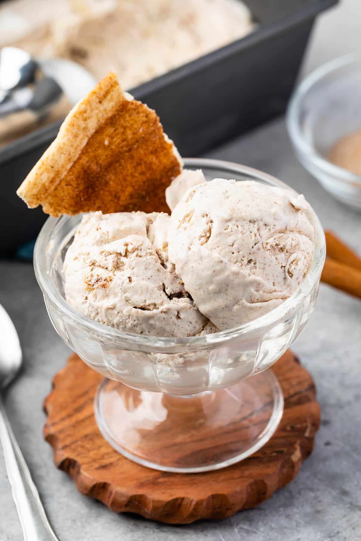 ice cream scooped into clear ice cream bowl and a churro piece mixed in.