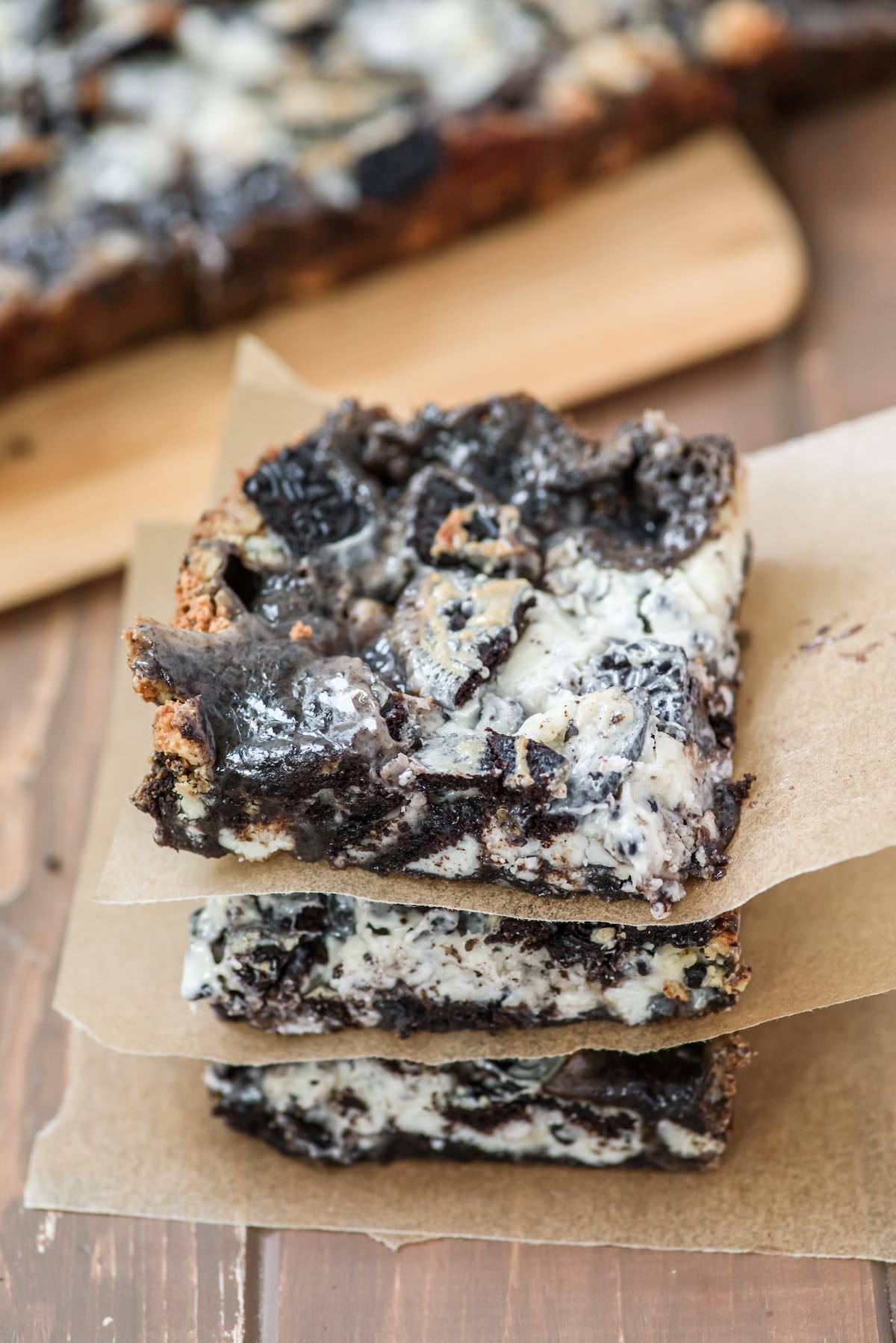 stacked oreo bars with parchment paper in between bars.